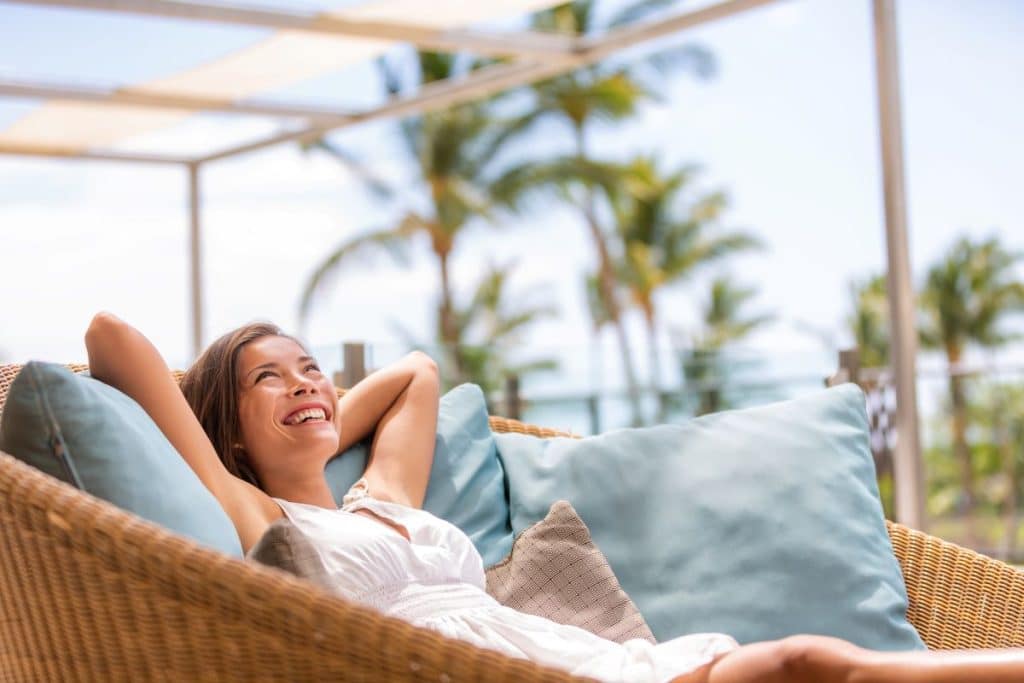 woman relaxing on outdoor lounge near the ocean representing hassle-free airbnb copywriting